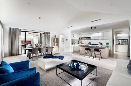 Elegant open-plan living space with sleek kitchen and vibrant blue sofas.