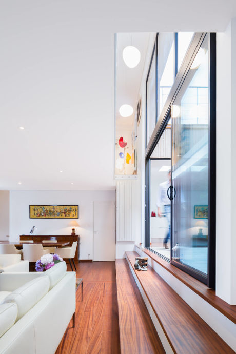 Bright contemporary interior with large windows and wooden floors.