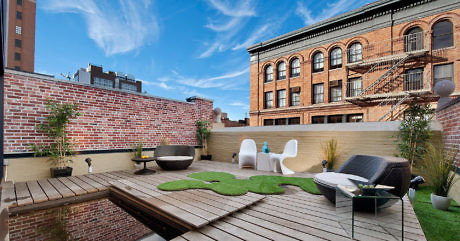 Chic rooftop terrace with wooden decking, unique furniture, and brick walls.