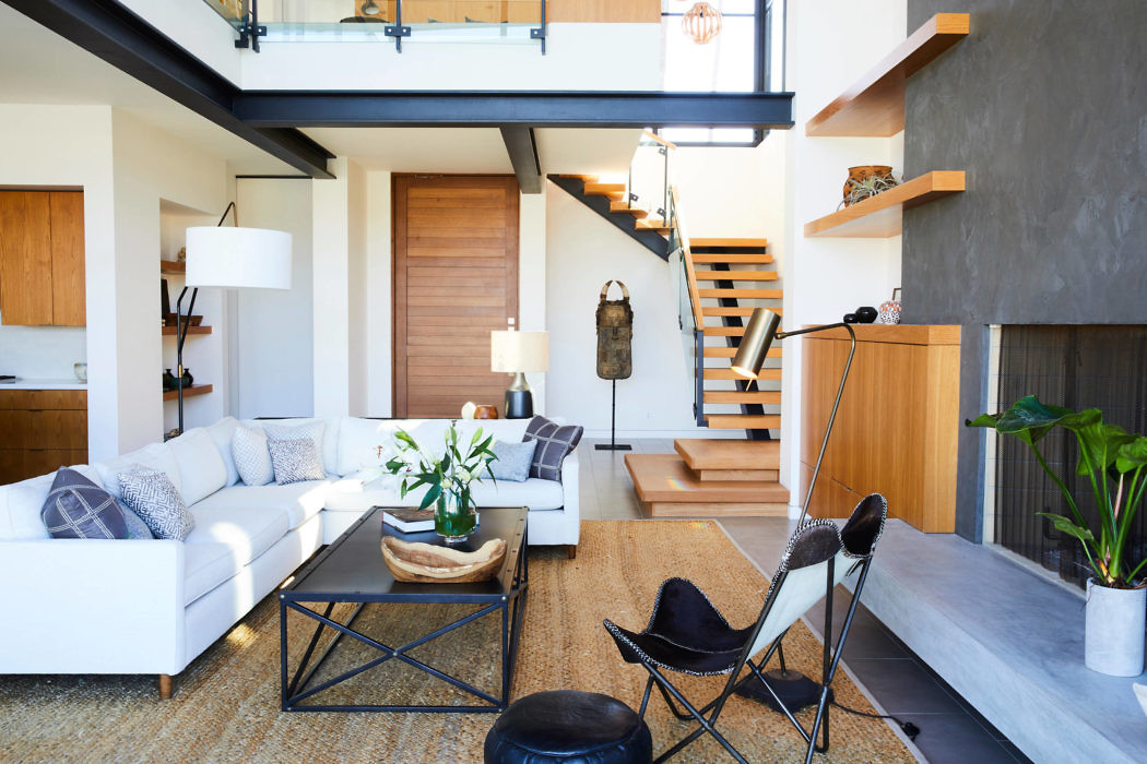 Stylish living room with open staircase and mezzanine.