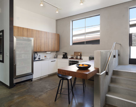 Modern kitchen with wooden cabinets, white appliances, and a breakfast bar.