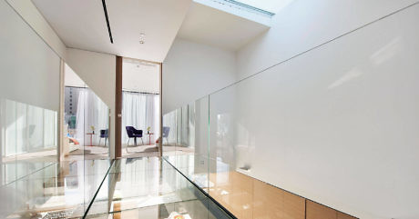Modern hallway with glass floor and white walls.