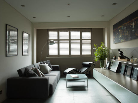 Modern living room with a gray sofa, lounge chair, and a large window with