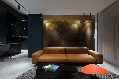 Chic interior with a tan couch, abstract art, and monochrome palette.