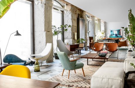 Modern living room with eclectic furniture and exposed concrete beams.