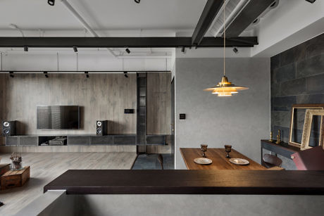 Modern apartment interior with exposed ceiling pipes, pendant light, and minimalist decor.