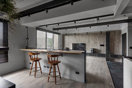 Modern kitchen with wooden accents and bar stools.