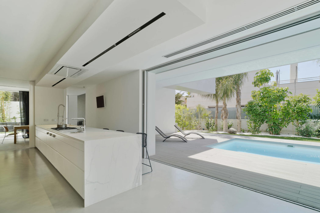 Modern kitchen with large sliding door opening to a pool area.