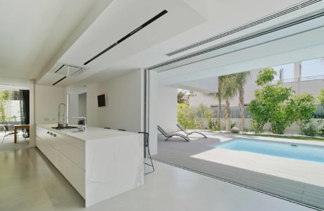 Modern kitchen with large sliding door opening to a pool area.