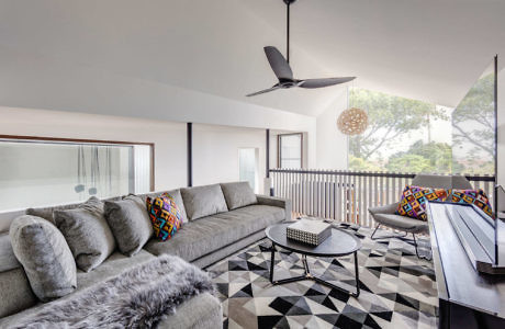 Modern living room interior with geometric rug and stylish furniture.