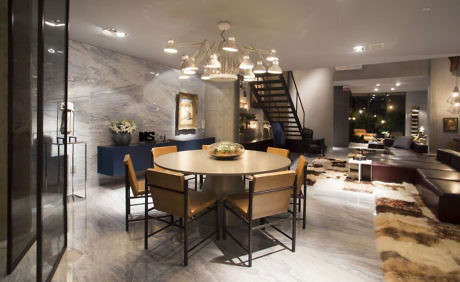 Elegant dining space with marble floors, chic staircase, and pendant lighting.