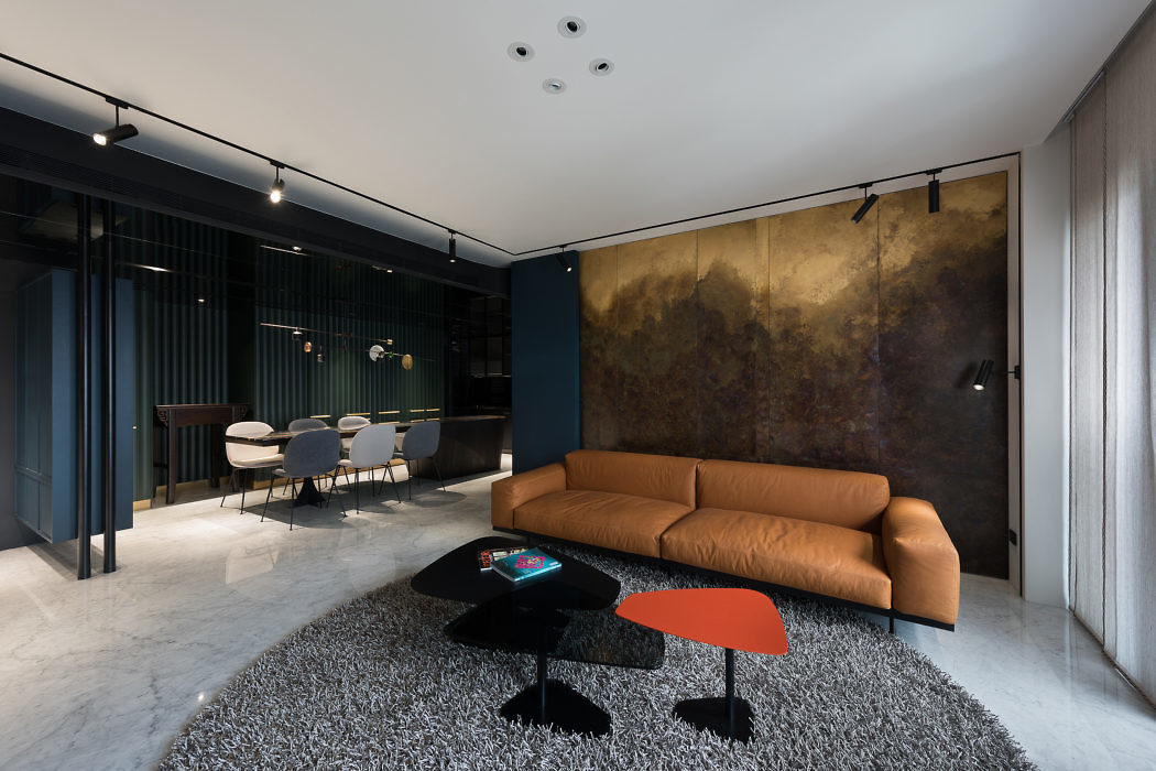 Modern living room with a tan sofa, black coffee table, and abstract art wall