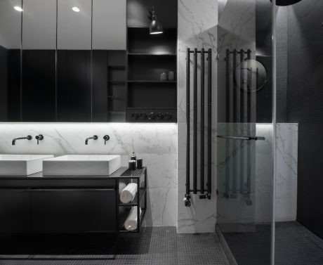Contemporary bathroom with marble walls, double vanity, and glass shower.