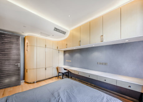 Modern bedroom with built-in cabinets, bed, and neutral tones.