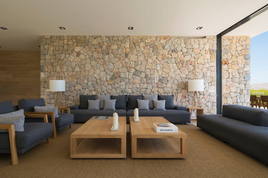 Contemporary living space with stone wall and plush seating.