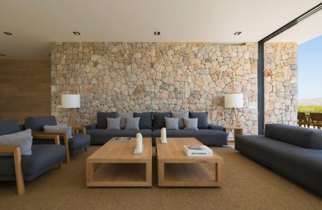 Contemporary living space with stone wall and plush seating.