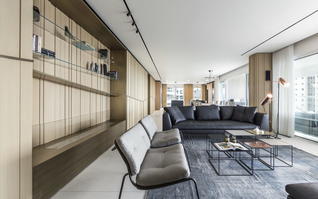 Contemporary living room with sleek furnishings and bookshelf wall.