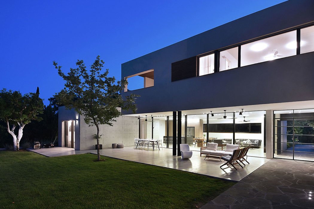 Contemporary house with large windows and open patio at dusk.