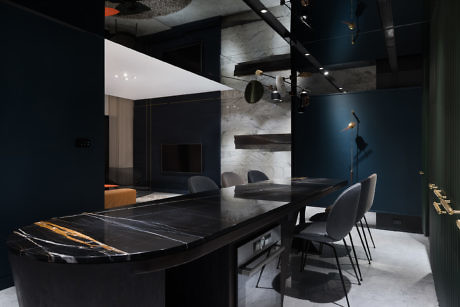 Contemporary kitchen with dark marble island and sleek furnishings.