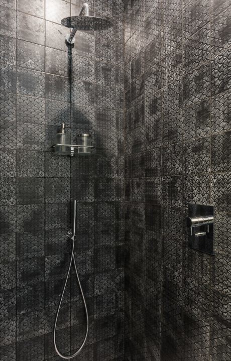 Modern shower with black mosaic tiles.