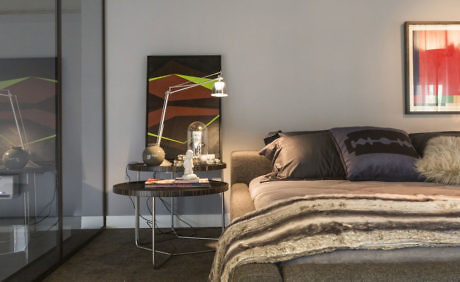 Contemporary bedroom with sleek decor and artwork.