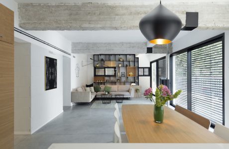 Modern living room with a minimalistic design, exposed ceiling, and large pendant light