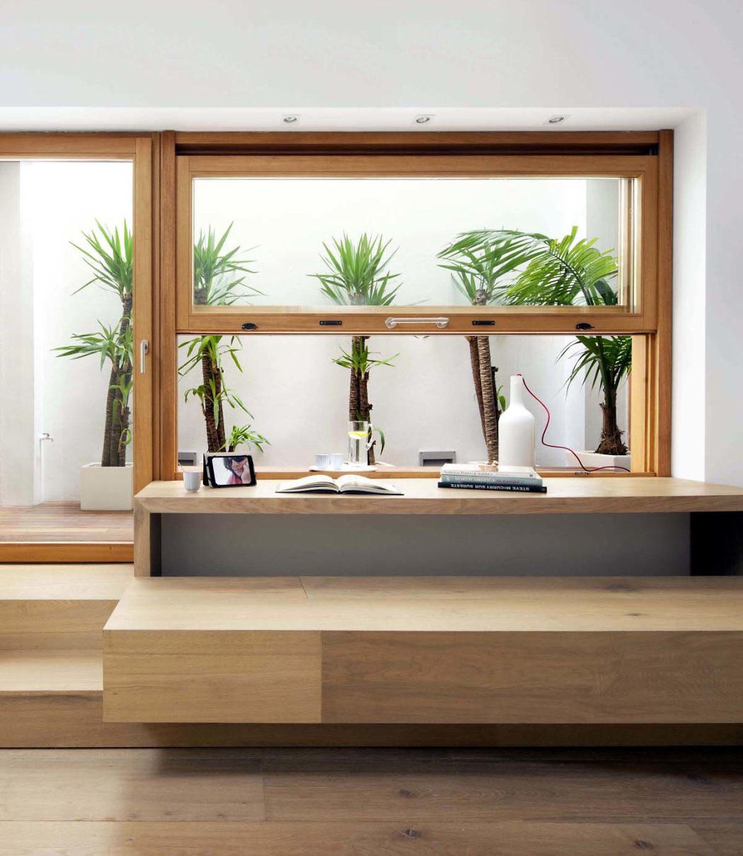 Contemporary wooden desk with plants and minimal decor.