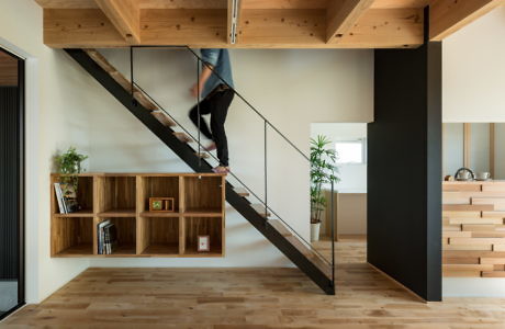 Contemporary interior with floating wooden staircase and bookshelf.