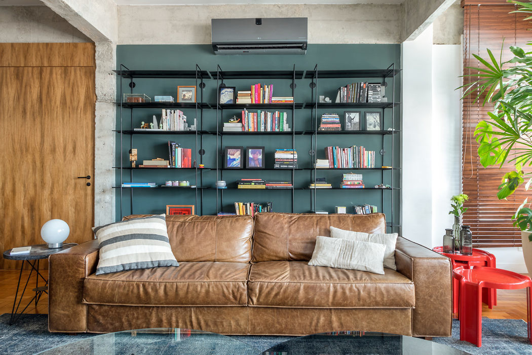 Modern living room with leather sofa and wall-mounted bookshelf.