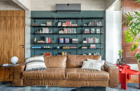 Modern living room with leather sofa and wall-mounted bookshelf.