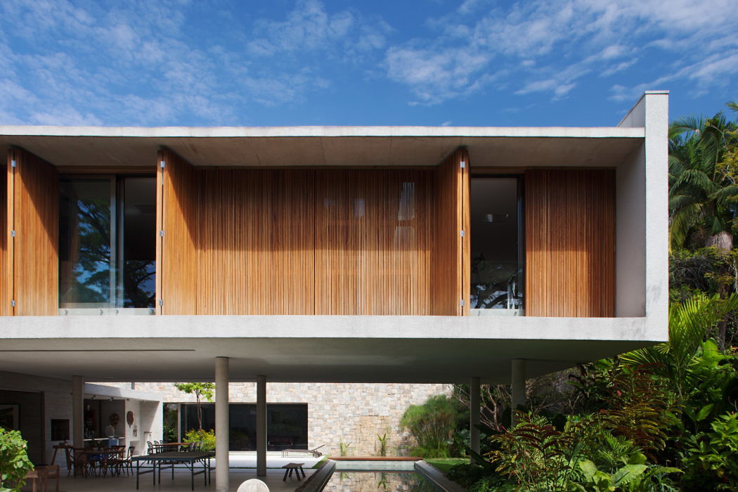 Contemporary house with large wooden sliding doors, cantilevered over a stone