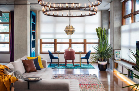 Modern living room with chic decor and large circular chandelier.