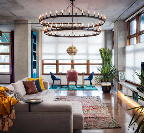 Modern living room with chic decor and large circular chandelier.