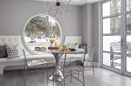 Minimalist breakfast nook with large round window and snow view.