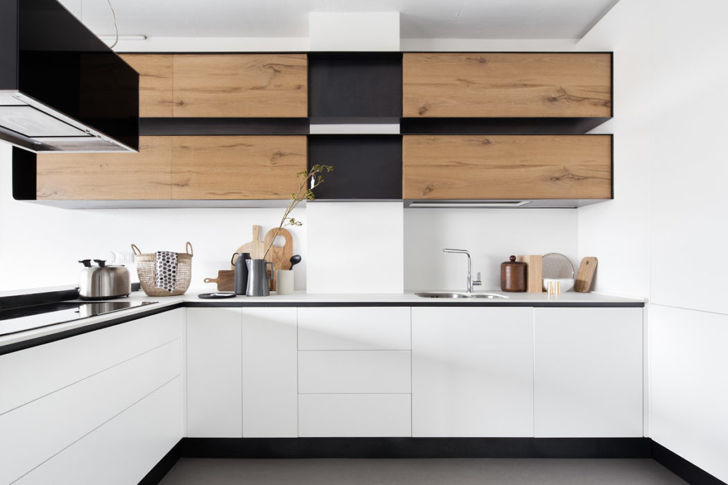 Contemporary kitchen with sleek white cabinets and wooden accents.