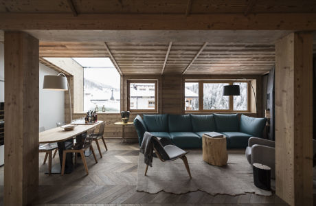 Contemporary wooden interior with teal sofa and herringbone floor.