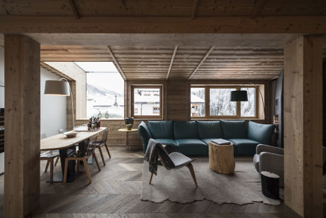 Contemporary wooden interior with teal sofa and herringbone floor.