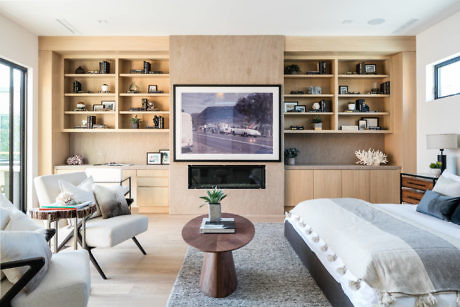 Modern living room with built-in shelves, neutral tones, and stylish furniture.
