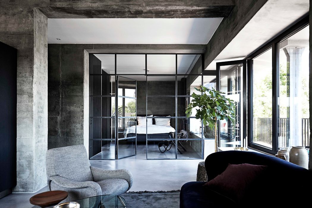 Industrial-style interior with exposed concrete and glass partitions.