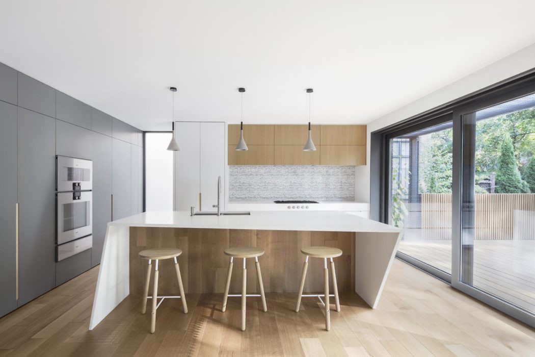 Contemporary minimalistic kitchen with sleek cabinetry and large windows.