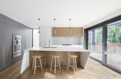 Contemporary minimalistic kitchen with sleek cabinetry and large windows.