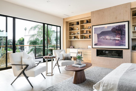 Modern living room with neutral tones, fireplace, and large windows.