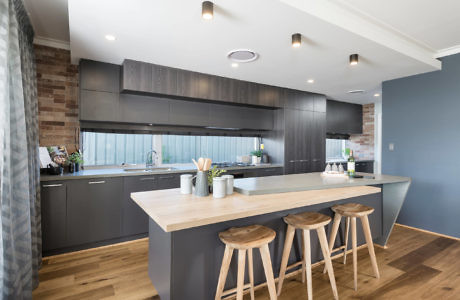 Modern kitchen interior with dark cabinets and a breakfast bar.