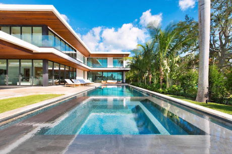 Contemporary house with pool and palm trees.