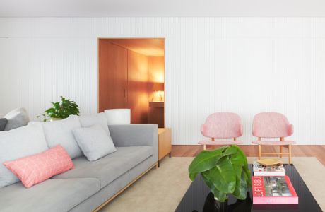 Modern living room with gray sofa, pink chairs, and a coffee table.