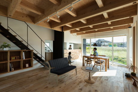 Minimalist interior with exposed wooden beams and staircase.
