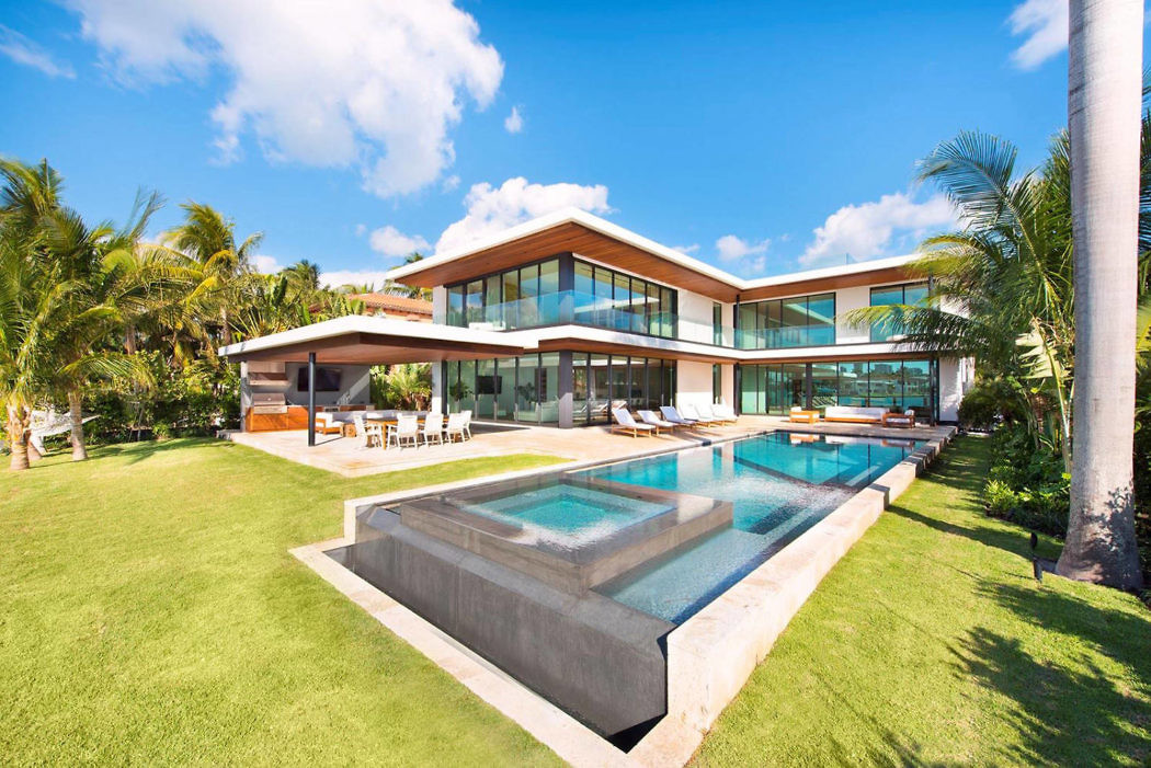 Contemporary beachfront villa with pool and large windows.