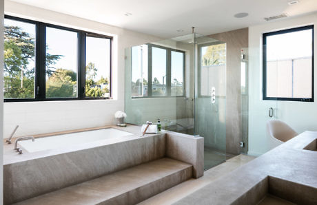 Sleek bathroom with large tub, glass shower, and expansive windows.