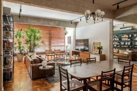 Contemporary living space with exposed beams, wooden floors, and lush indoor plants.