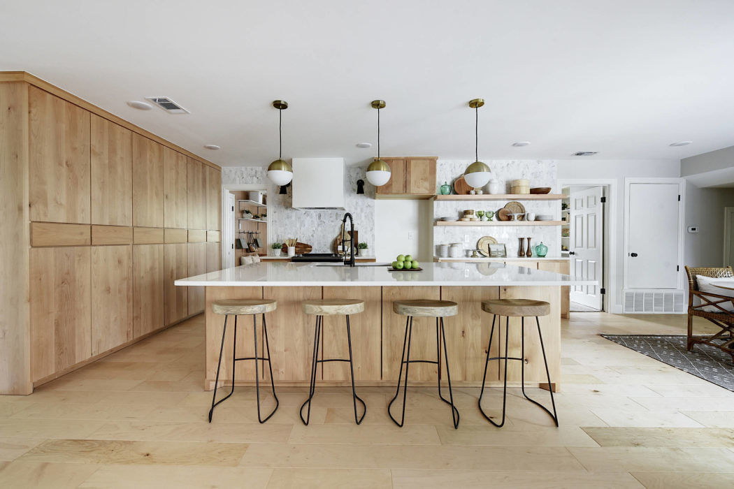 Minimalist kitchen with light wood cabinetry and pendant lighting.